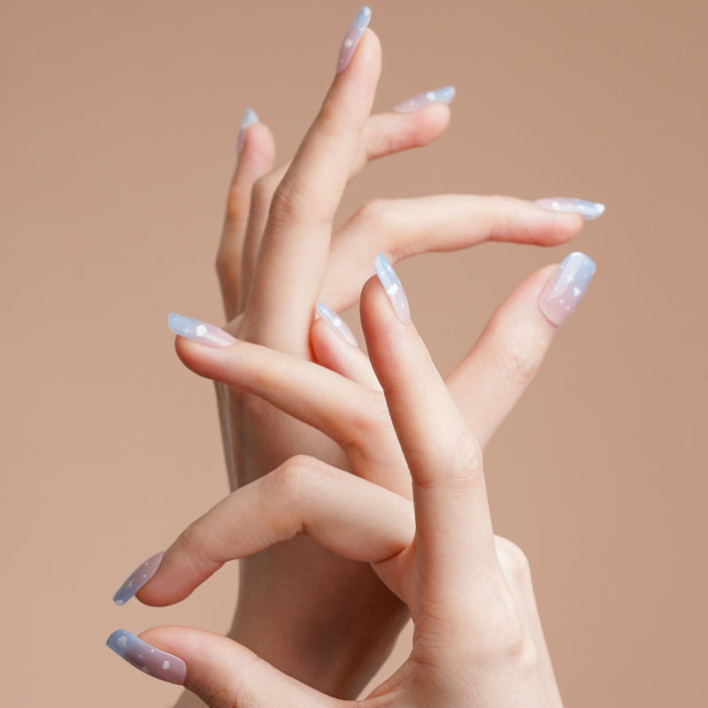 Stickers ongles gel Celiora bleu ciel avec nuages blancs, étoiles et base rosée