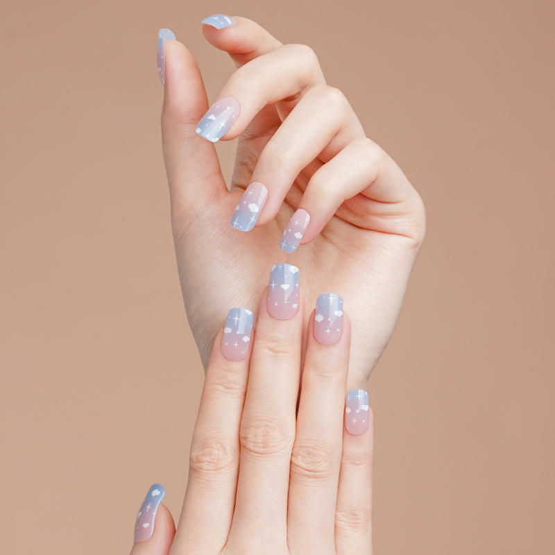 Stickers ongles gel Celiora bleu ciel avec nuages blancs, étoiles et base rosée